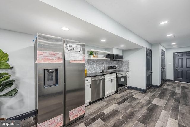 kitchen with sink, dark wood-type flooring, decorative backsplash, white cabinets, and appliances with stainless steel finishes