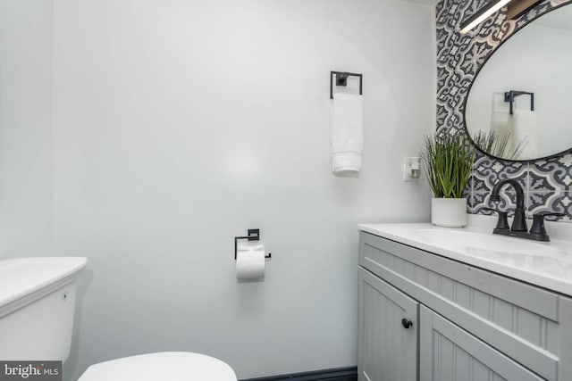 bathroom featuring decorative backsplash, vanity, and toilet