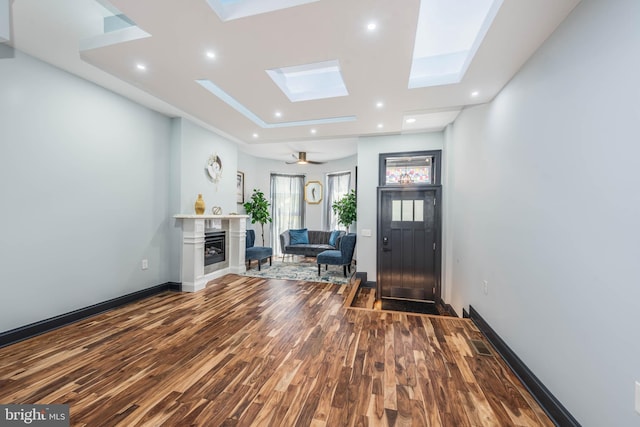 foyer entrance with a skylight, ceiling fan, and hardwood / wood-style floors