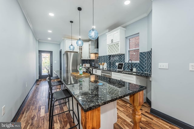 kitchen with decorative light fixtures, a center island, stainless steel appliances, and a breakfast bar area