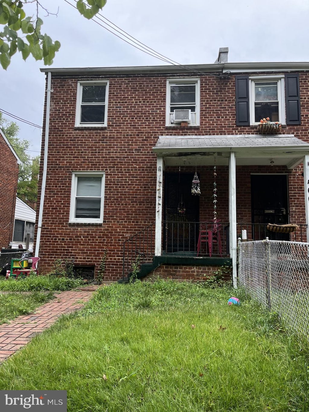 view of front of home featuring a front yard, a porch, and cooling unit