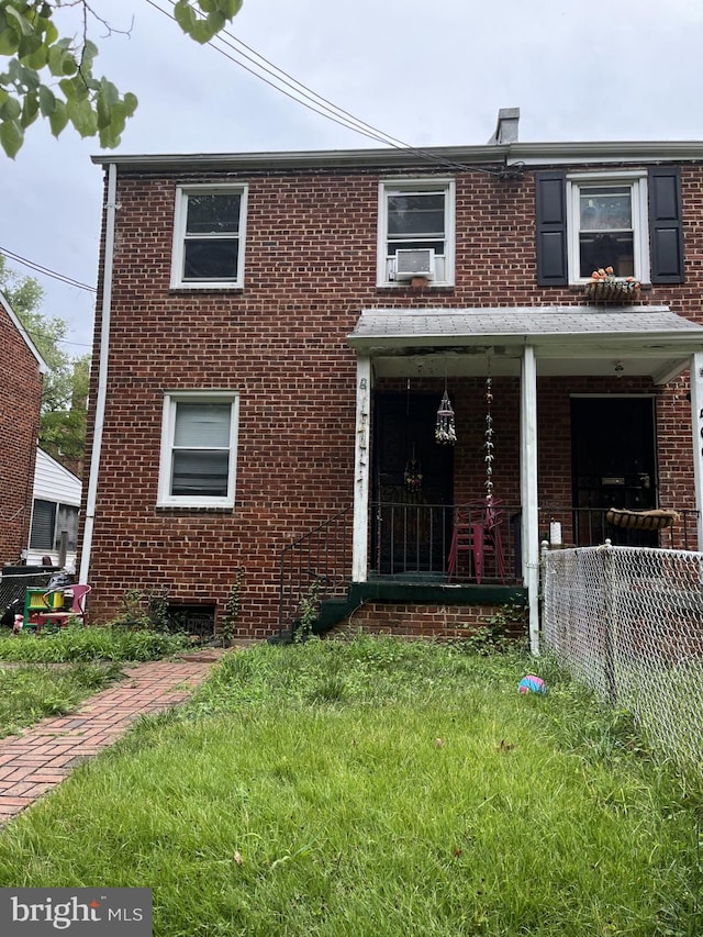 view of front of home featuring a front yard, a porch, and cooling unit