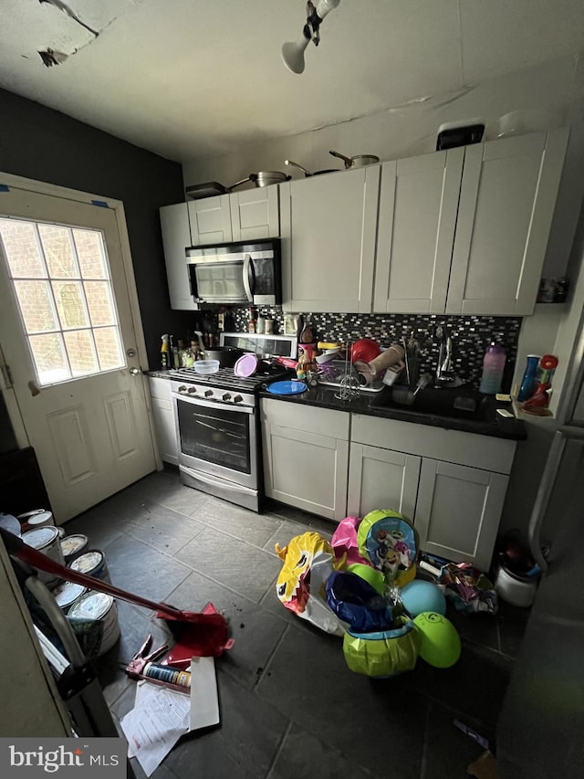 kitchen featuring light tile patterned floors, stainless steel appliances, and tasteful backsplash