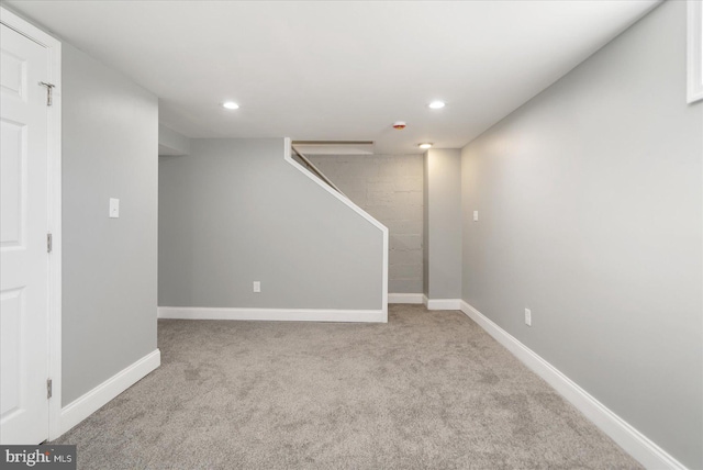 basement featuring light carpet