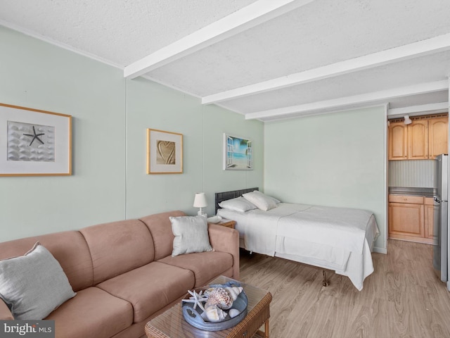 bedroom with stainless steel fridge, beam ceiling, a textured ceiling, and light hardwood / wood-style flooring