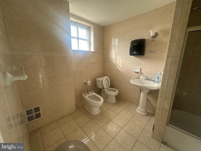 bathroom featuring tile patterned floors, bath / shower combo with glass door, a bidet, tile walls, and toilet