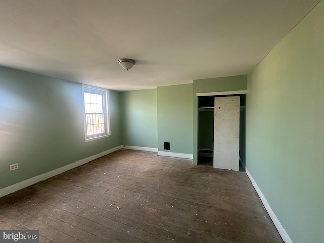 unfurnished bedroom featuring dark hardwood / wood-style floors and a closet