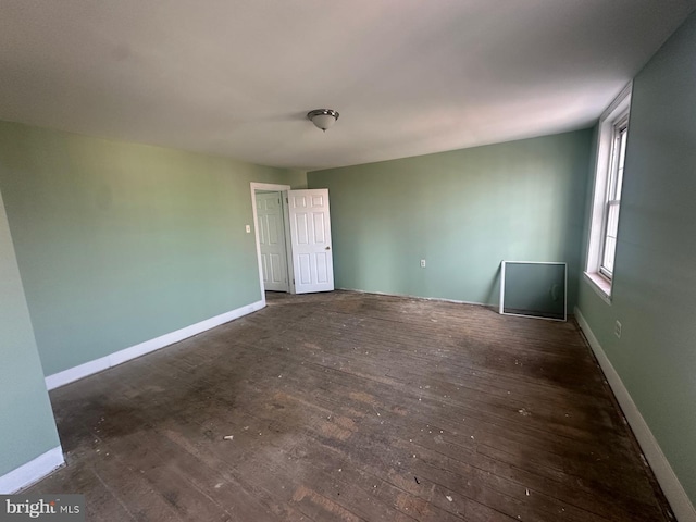 empty room with dark hardwood / wood-style flooring