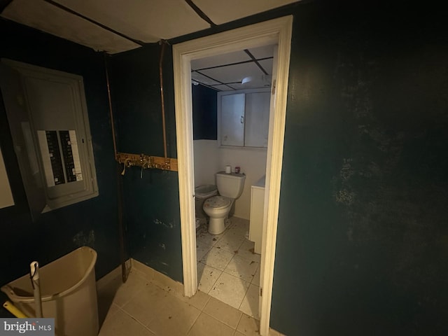 bathroom with tile patterned floors, electric panel, and toilet