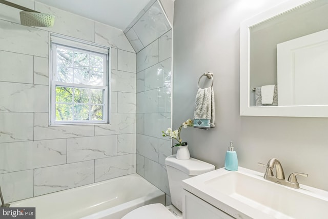 full bathroom featuring tiled shower / bath, vanity, and toilet