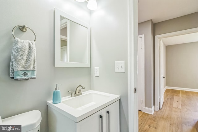 bathroom featuring hardwood / wood-style floors, vanity, and toilet