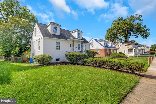 cape cod house featuring a front lawn