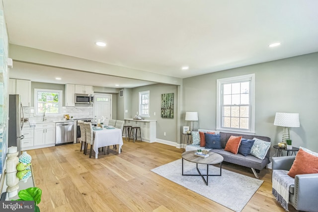 living room featuring sink and light hardwood / wood-style floors