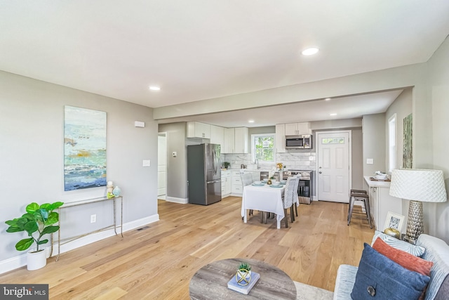 living room with light hardwood / wood-style floors and sink