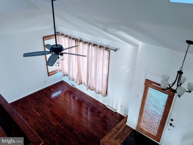 interior space with visible vents, ceiling fan with notable chandelier, baseboards, and wood finished floors