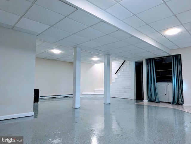 basement with a paneled ceiling, washer / clothes dryer, and a baseboard radiator