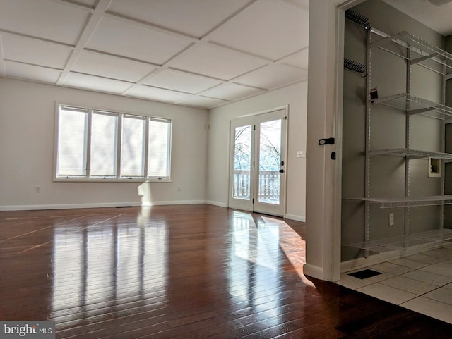 spare room featuring hardwood / wood-style floors, baseboards, and coffered ceiling