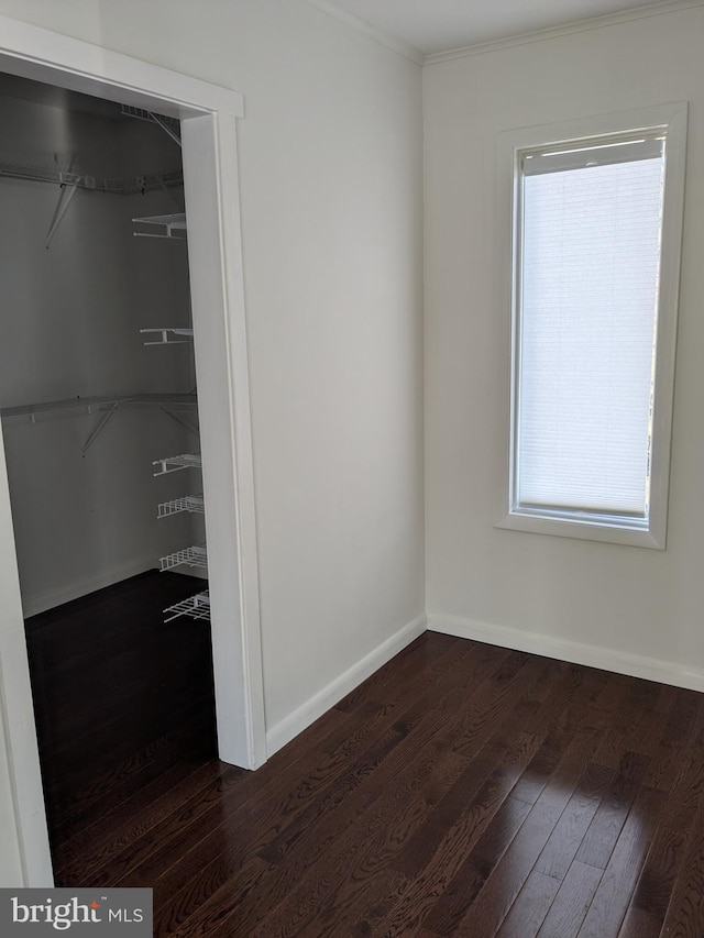 interior space featuring baseboards and dark wood finished floors