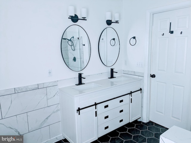 bathroom with double vanity, tile patterned floors, tile walls, and a sink