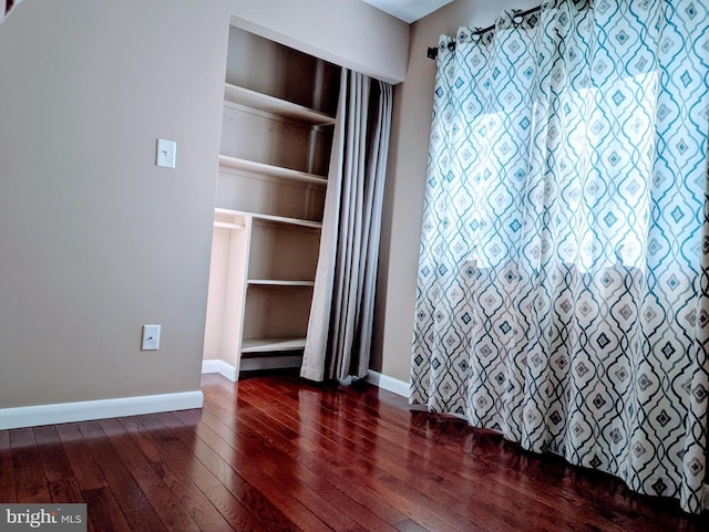 interior space with baseboards and dark wood-style flooring