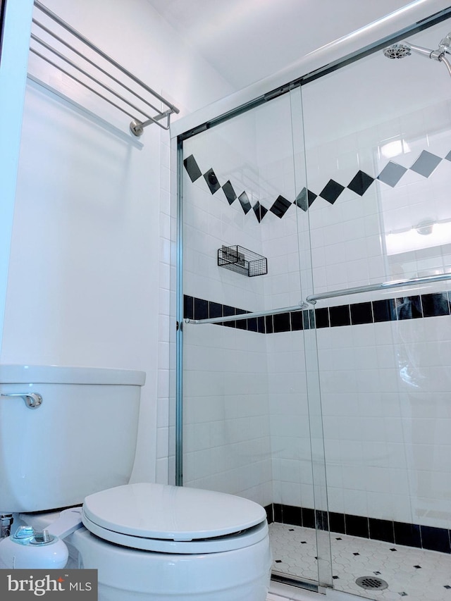 bathroom with a shower stall and toilet