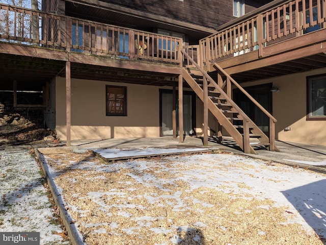 back of house with a patio area, stucco siding, a wooden deck, and stairs