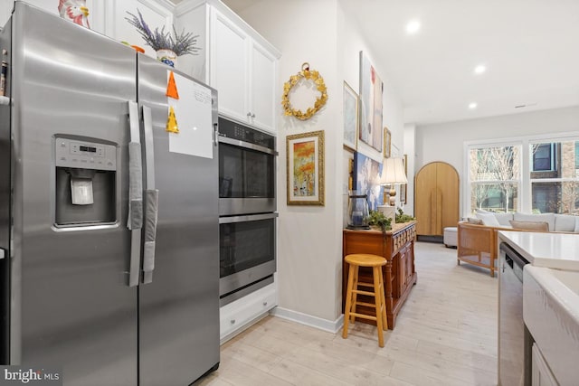 kitchen featuring white cabinets, stainless steel appliances, and light hardwood / wood-style flooring