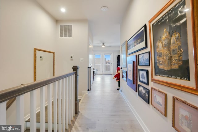 corridor featuring light hardwood / wood-style flooring and french doors