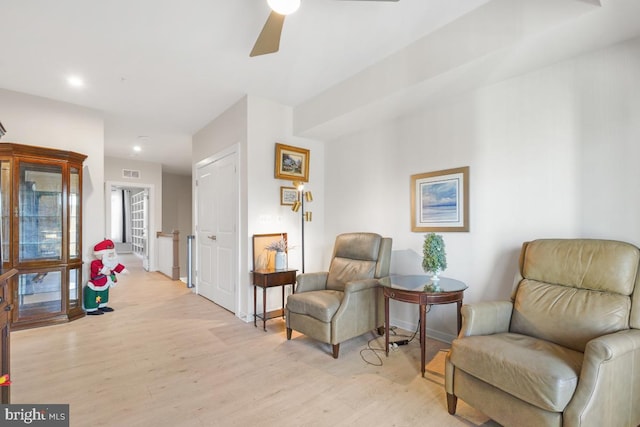 living area featuring ceiling fan and light hardwood / wood-style flooring