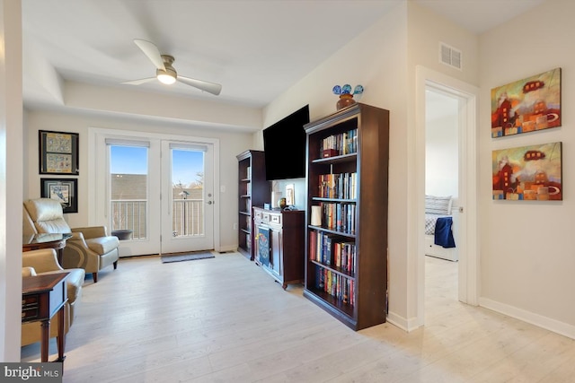 sitting room with ceiling fan and light hardwood / wood-style flooring