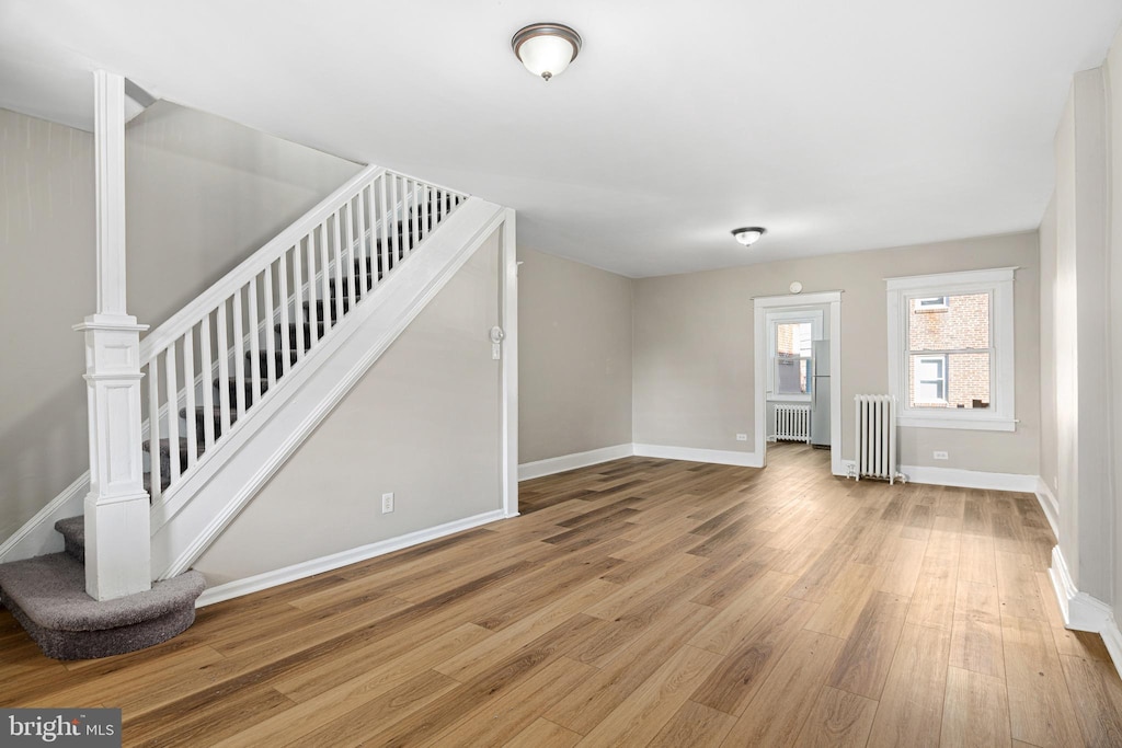 interior space with light wood-type flooring and radiator heating unit