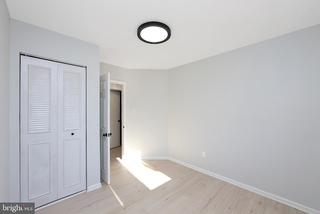 unfurnished bedroom featuring light hardwood / wood-style flooring and a closet