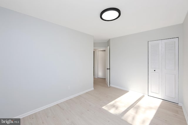 unfurnished bedroom featuring a closet and light hardwood / wood-style floors