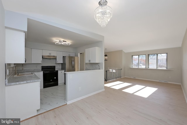 kitchen with sink, a notable chandelier, black electric range, white cabinetry, and stainless steel refrigerator