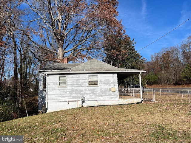 view of home's exterior with a carport and a lawn