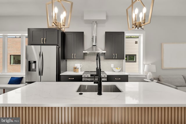 kitchen featuring decorative backsplash, light stone counters, an inviting chandelier, stainless steel fridge with ice dispenser, and hanging light fixtures