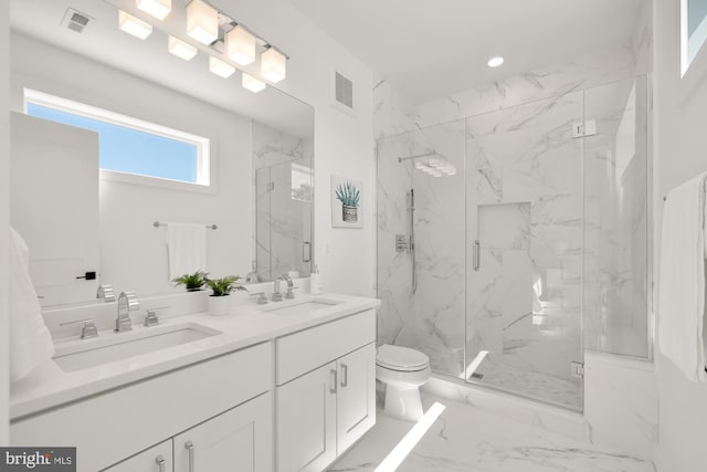 bathroom featuring vanity, toilet, and a shower with shower door