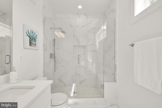 bathroom with vanity, a shower with shower door, and toilet