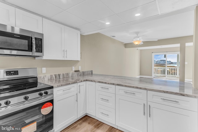 kitchen featuring white cabinets, ceiling fan, kitchen peninsula, and appliances with stainless steel finishes