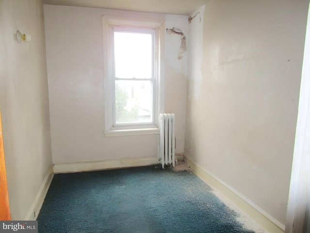 empty room featuring carpet flooring and radiator