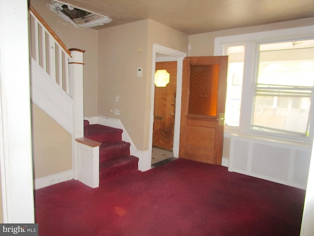 foyer featuring carpet flooring and radiator heating unit