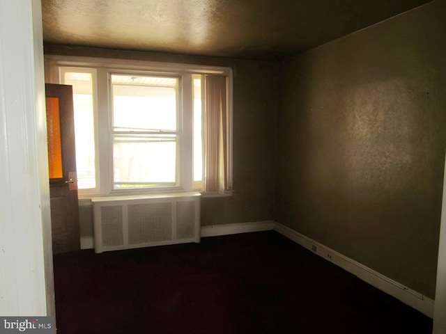 empty room with a textured ceiling and radiator