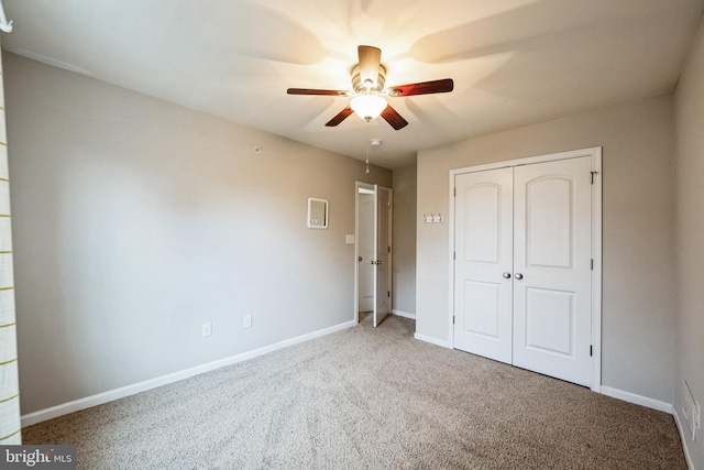 unfurnished bedroom with ceiling fan, a closet, and carpet