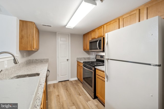 kitchen featuring stainless steel appliances, light hardwood / wood-style floors, and sink