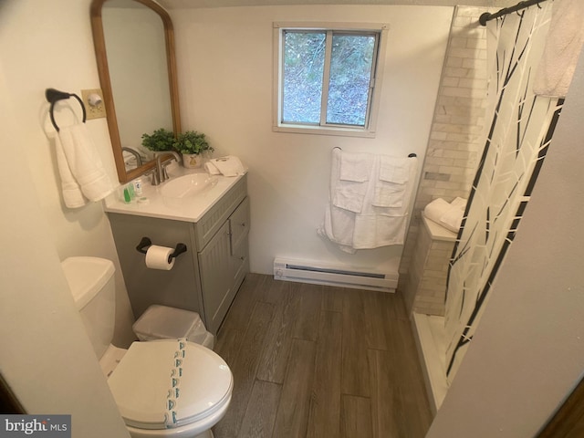 bathroom with walk in shower, vanity, a baseboard heating unit, hardwood / wood-style flooring, and toilet