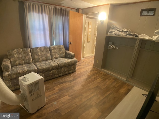 living room with hardwood / wood-style floors and wooden walls