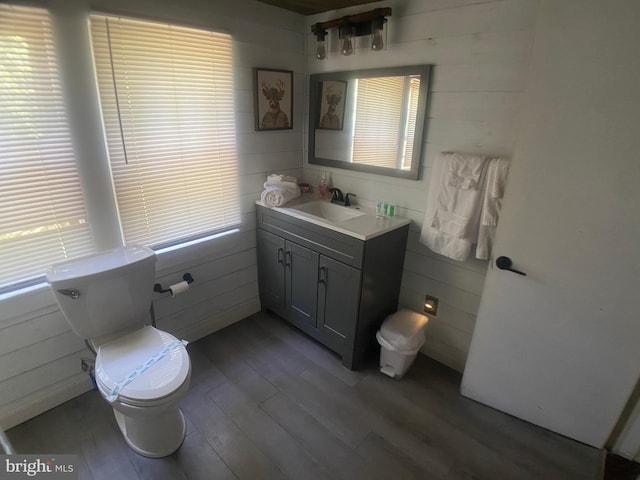 bathroom with hardwood / wood-style floors, a wealth of natural light, and wooden walls