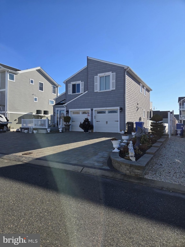 view of front facade featuring a garage, a deck, and central air condition unit