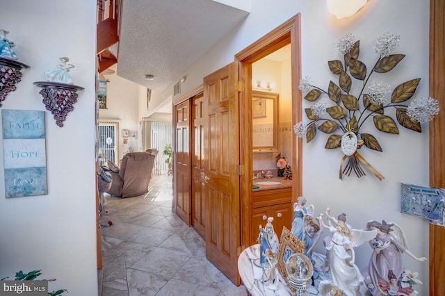 hallway with sink and a textured ceiling