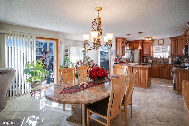 dining space featuring plenty of natural light, light tile patterned floors, a textured ceiling, and an inviting chandelier